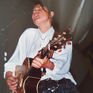 Auf dem Foto ist die Singer-Songwriterin Barbara Clear mit Gitarre zu sehen.