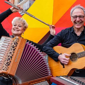 Auf dem Bild sind die beiden Musiker vom Duo Kaleido mit ihrem Instrumenten vor einer bunten Wand zu sehen.