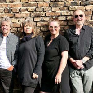 Auf dem Bild sind die sechs Musiker der Funkkapelle Rodheim vor einer Mauer stehend zu sehen.