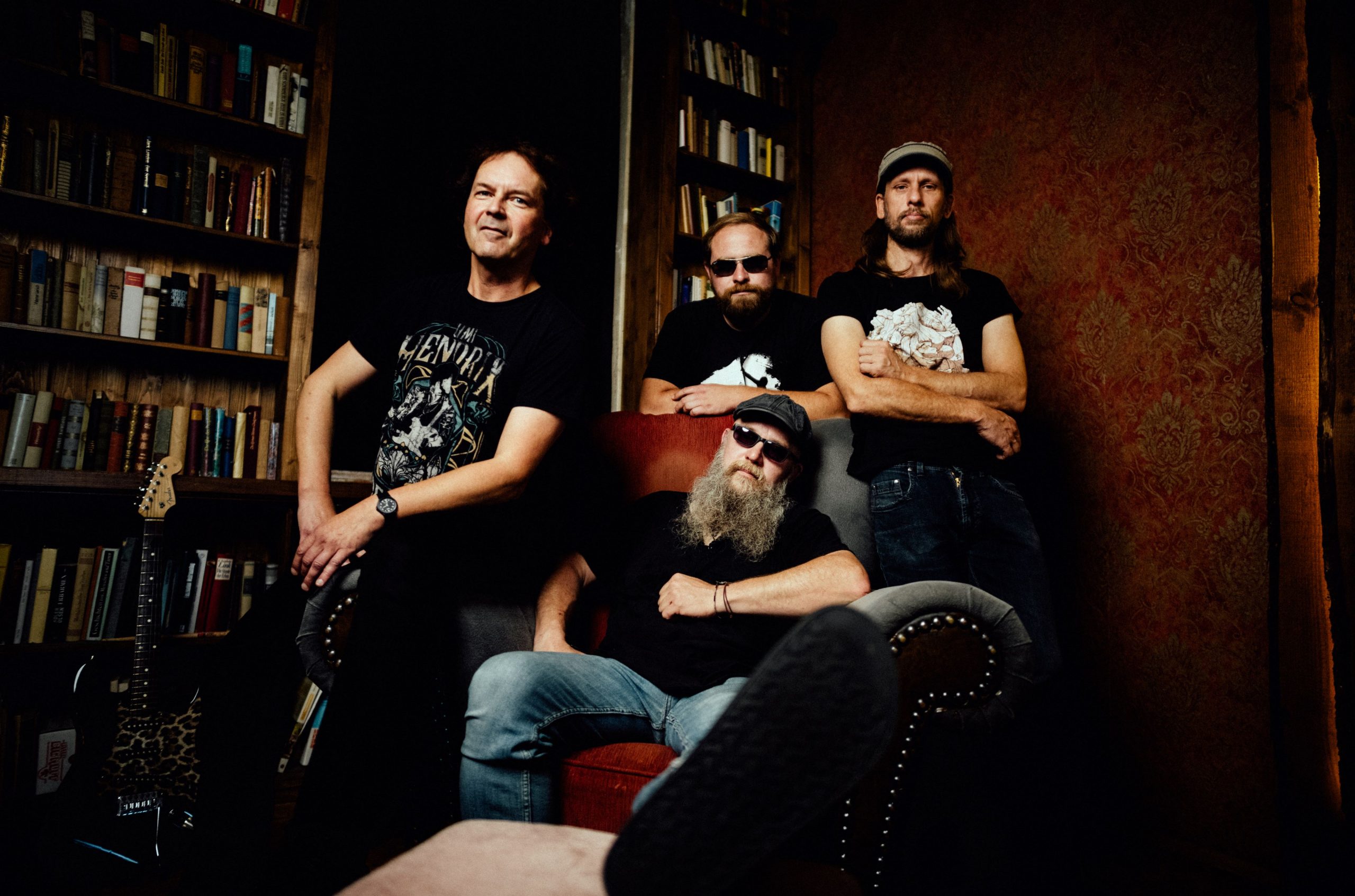Auf dem Bild ist die vierköpfige Band Hot'n'Nasty vor einer Bücherwand stehend zu sehen.