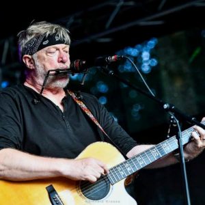 Auf dem Bild ist Paddy Schmidt mit einer Gitarre in der Hand zu sehen.