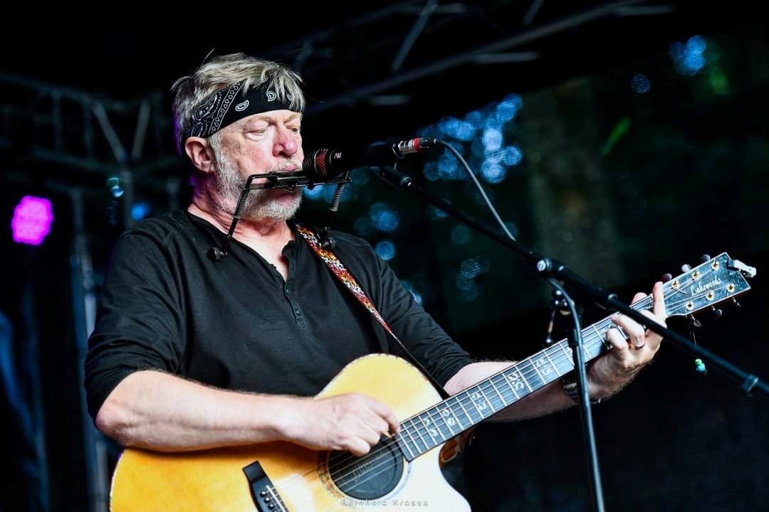 Auf dem Bild ist Paddy Schmidt mit einer Gitarre in der Hand zu sehen.