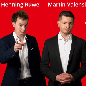 Auf dem Bild sind Henning Ruwe und Martin Valenske vor rotem Hintergrund zu sehen.