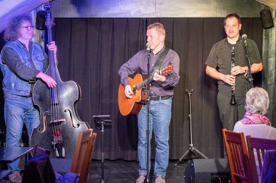 Auf dem Bild sind die drei Musiker von Shebeen Connection auf der Bühne zu sehen.