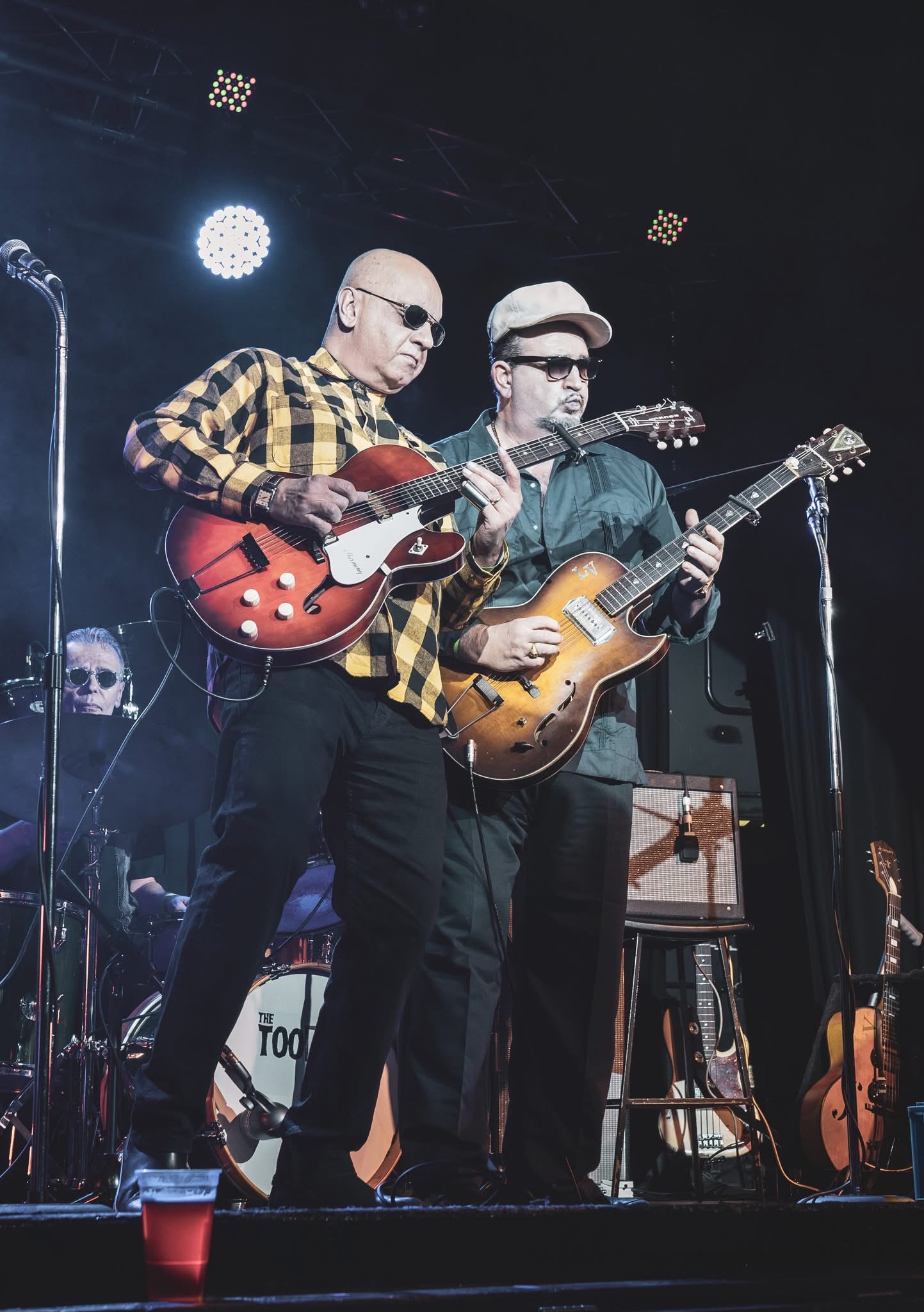 Auf dem Fotos sind zwei Musiker der Band The Too Bad Jims mit Instrumenten auf der Bühne zu sehen.