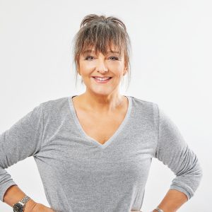 Auf dem Bild ist Rena Schwarz in einem grau-melierten Pullover zu sehen.