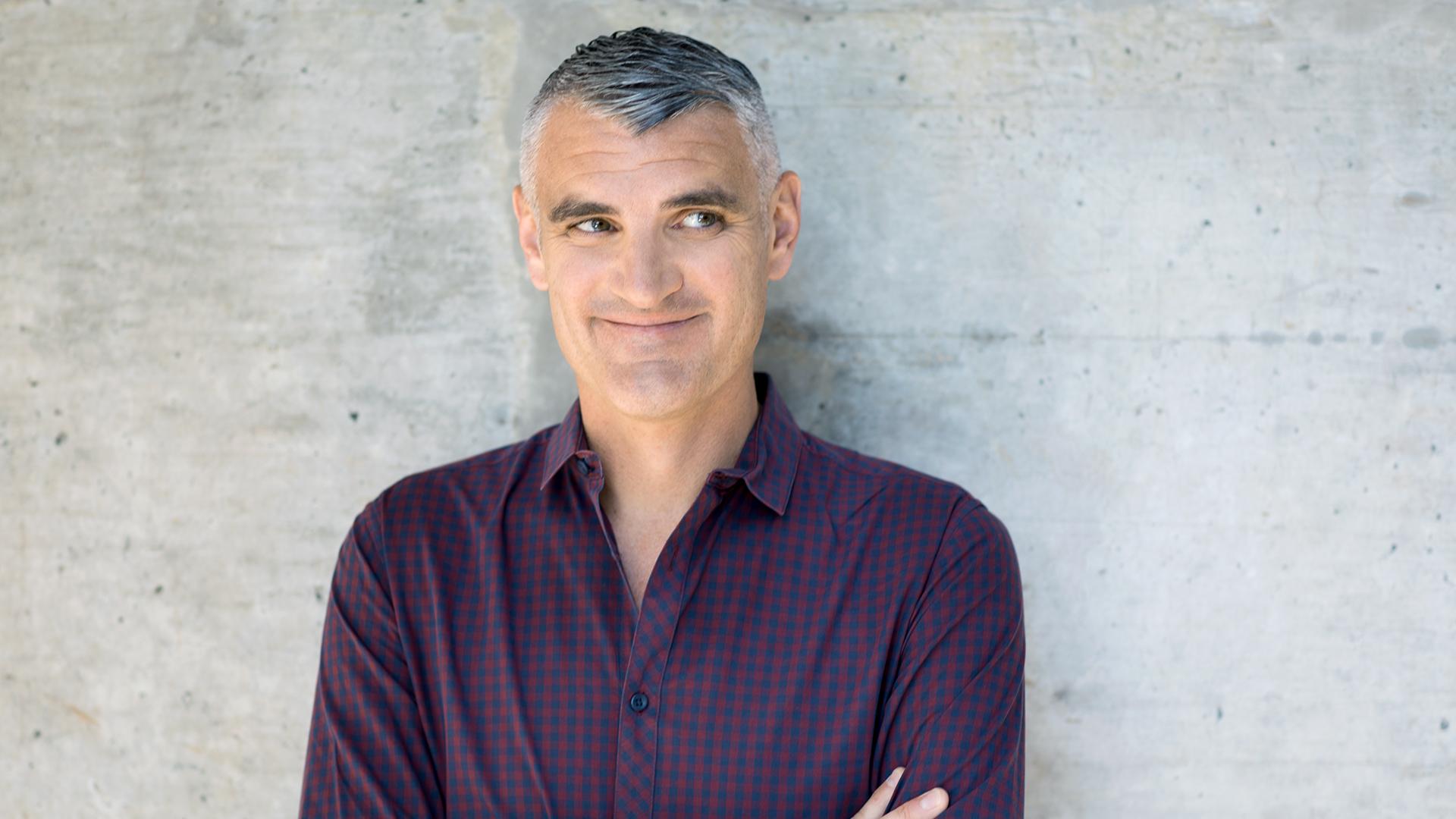 Auf dem Bild ist Tim Frühling vor einer Wand zu sehen.